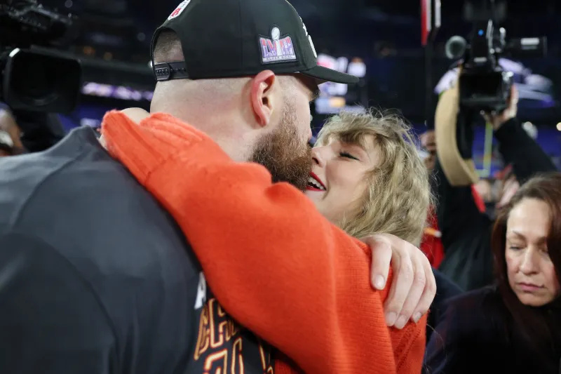 Taylor Swift küsst Travis Kelce auf dem Spielfeld, während er den AFC-Meisterschaftssieg der Chiefs feiert