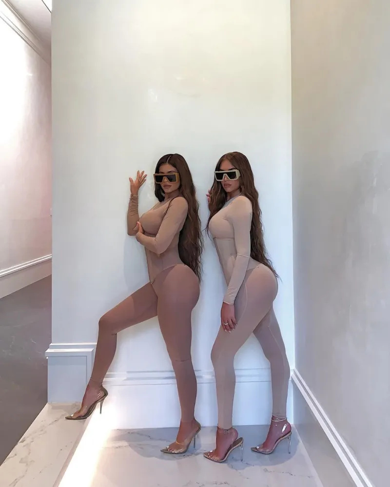   Kylie Jenner و Stassie Karanikolaou يرتديان ملابس داخلية عارية متناسقة وكعب عالٍ مع نظارة شمسية أثناء وقوفهما أمام جدار أبيض