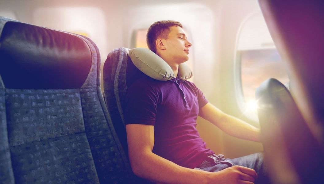 bărbat dormind într-un avion